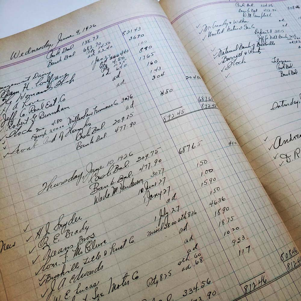 Close-up image of a handwritten ledger showing daily sales entries and financial transactions